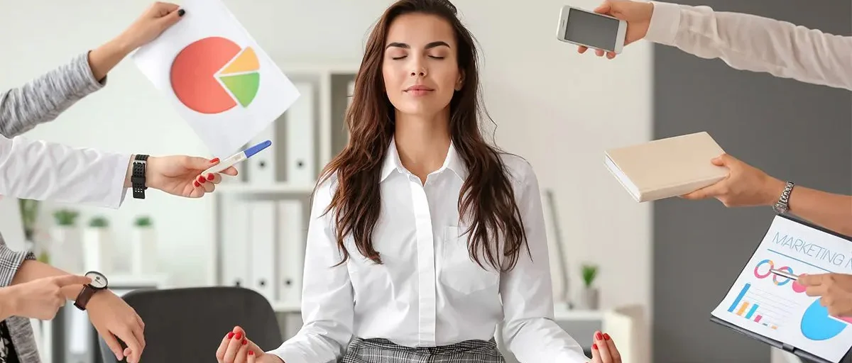 Ofis yoğunluğu içinde meditasyon yapan kadın çalışan