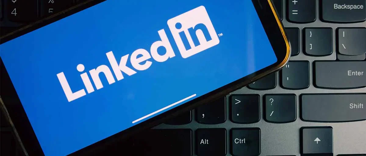 Klavye üzerine konuşmuş, ekranında LinkedIn açılmış bir telefon