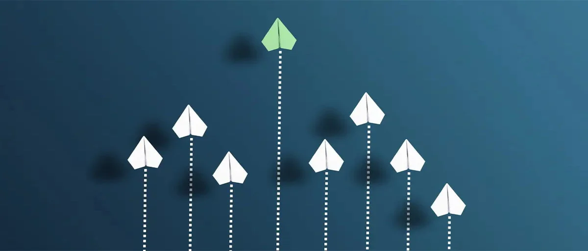 Leading, green, paper airplane, followed by 7 white paper airplanes - representation of the concept of leadership