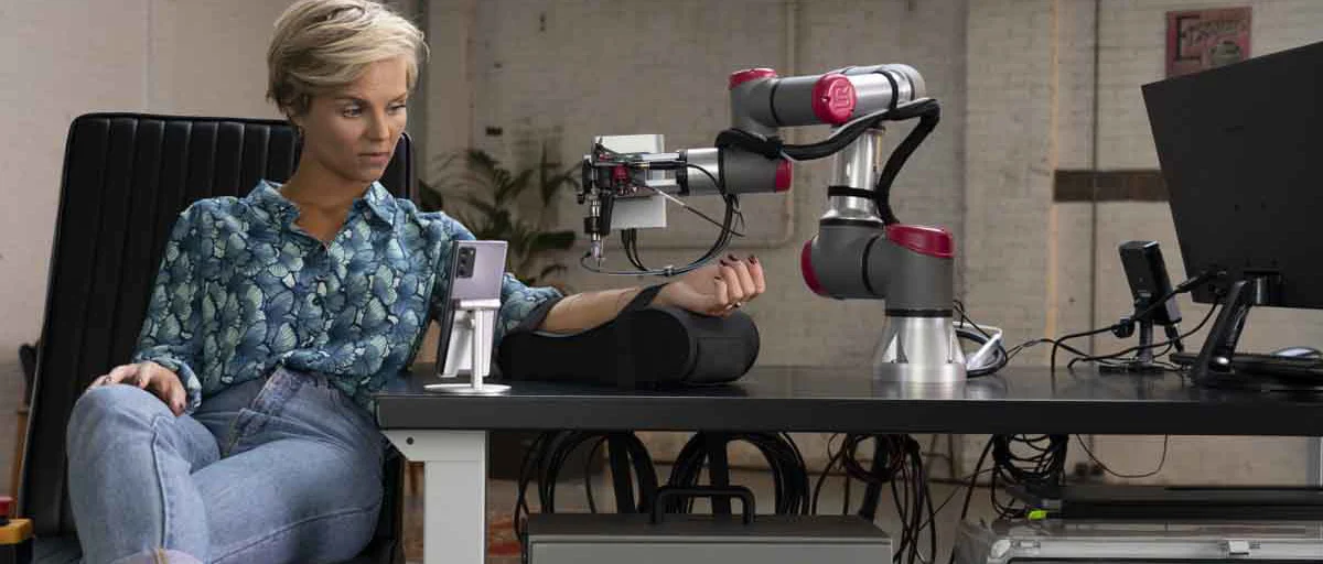 Dövme yapan bir robot kol