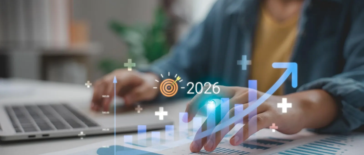 bilgisayar başındaki birinin elleri. 2026 yazısı ve bir artış grafiği